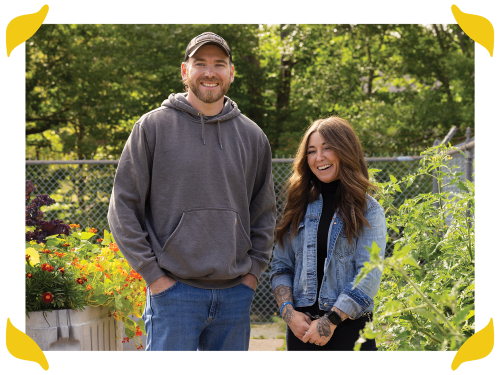 A man and woman standing together in an outdoor community garden