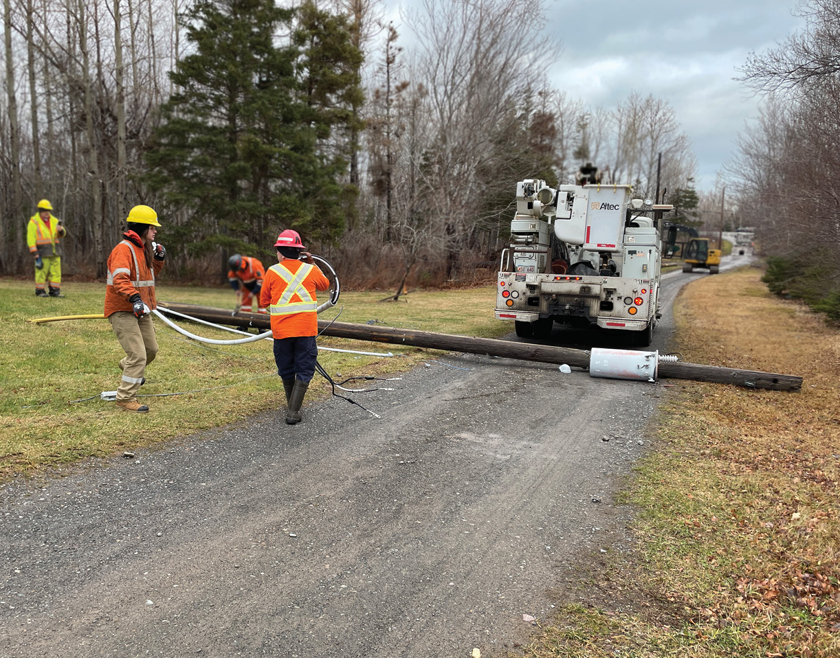 power employees in safety gear fixing a downed power pole