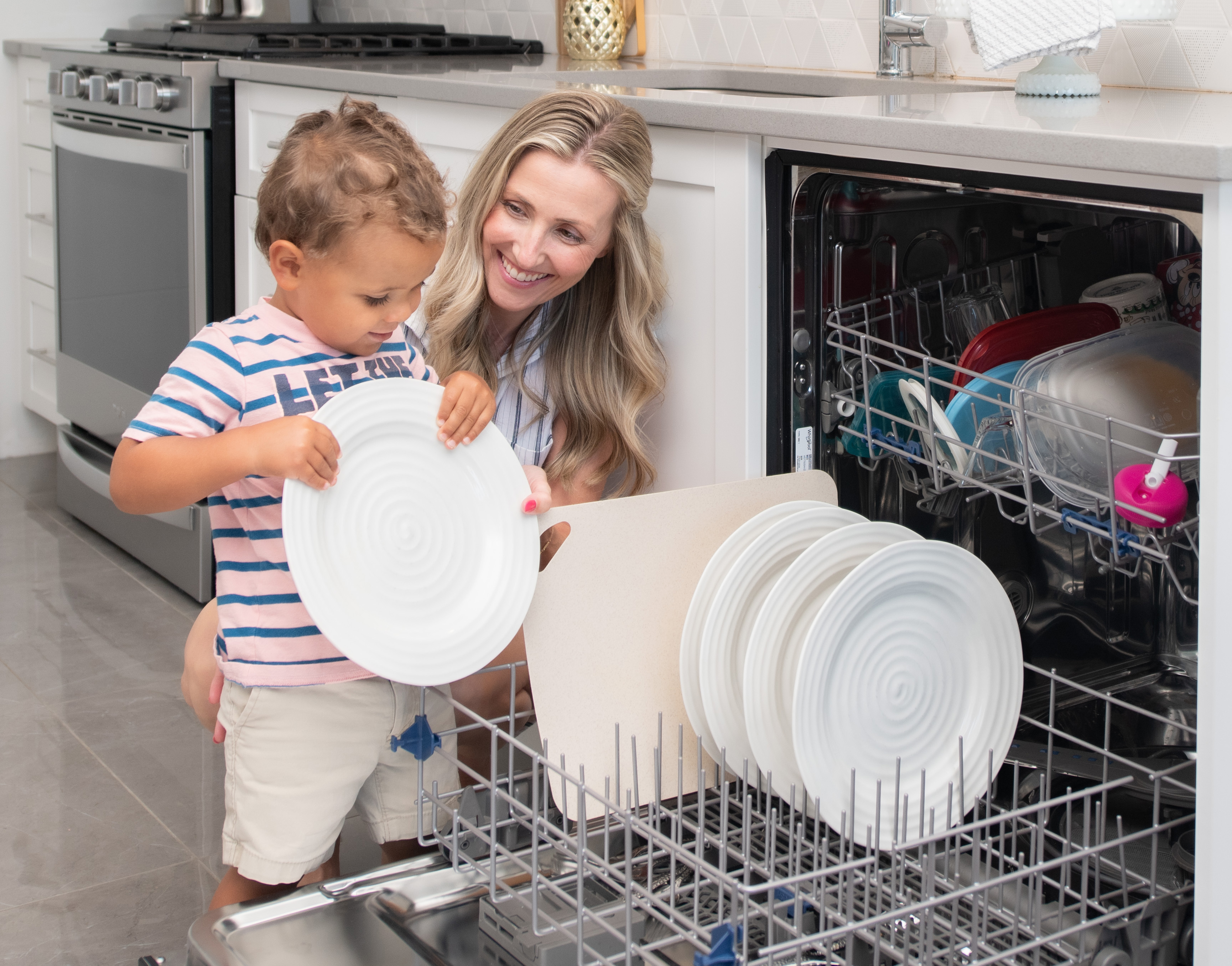 mother and child loading a dishwasher